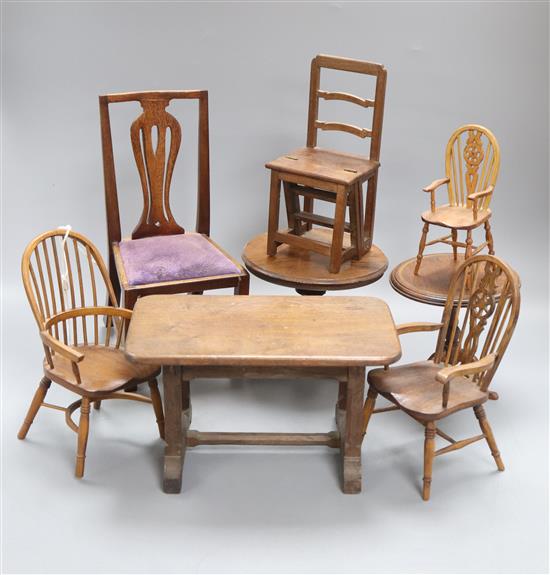 A group of miniature wood furniture including three Windsor chairs, a vase splat chair, two tripod tables, a metamorphic library chair